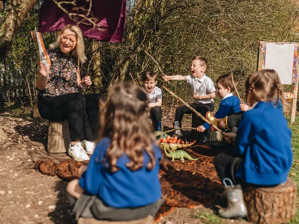 Children enjoying a Forest School session with their teacher at Early Years Educare